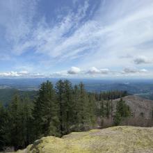 Panorama of view from summit with man standing at left
