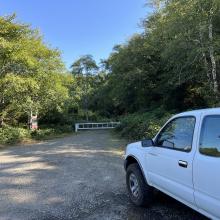 Truck parked at the side of the road with a gate in the background